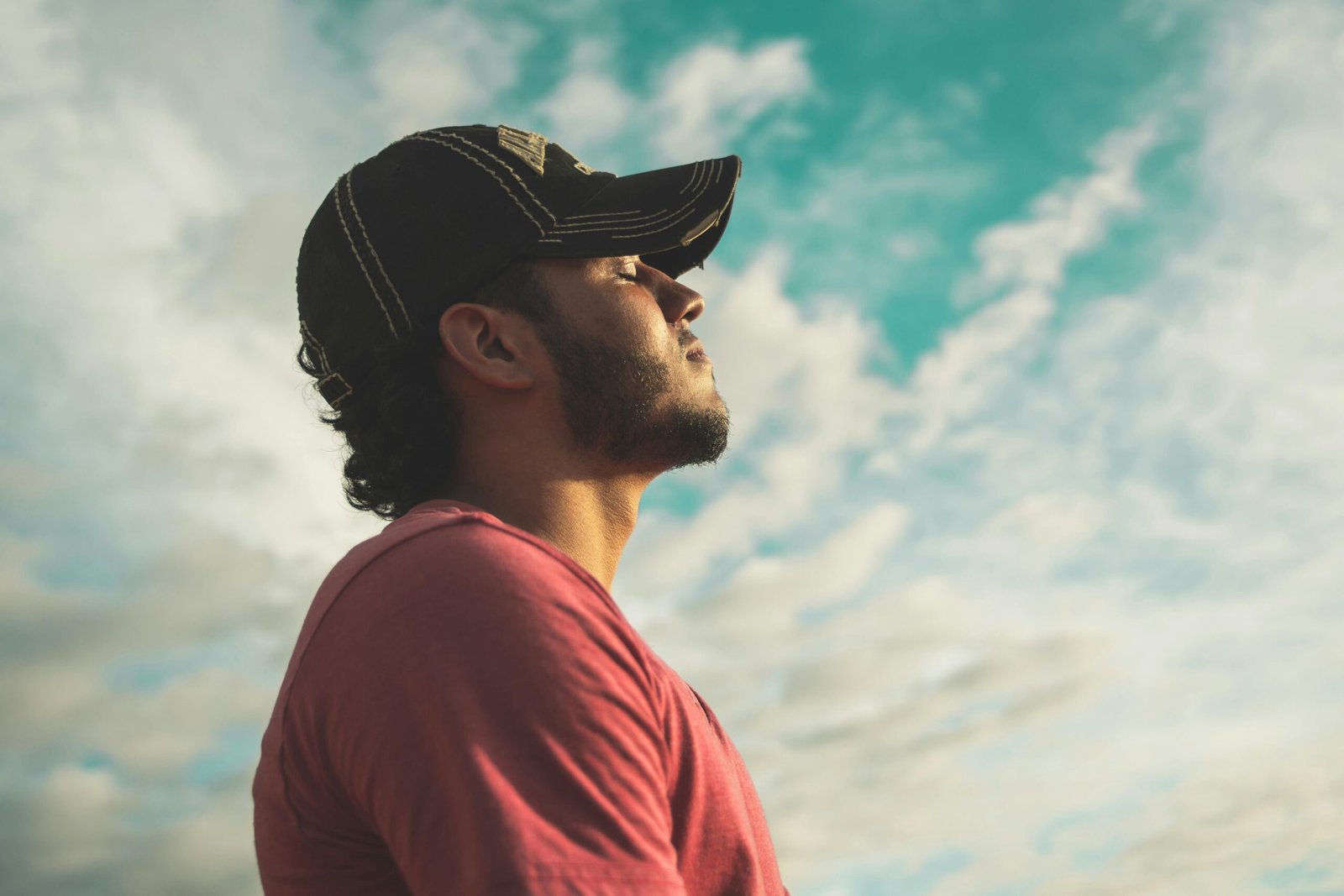 Method A man enjoys outdoor relaxation and mindfulness beneath a bright, cloudy sky, exuding calm and peace.